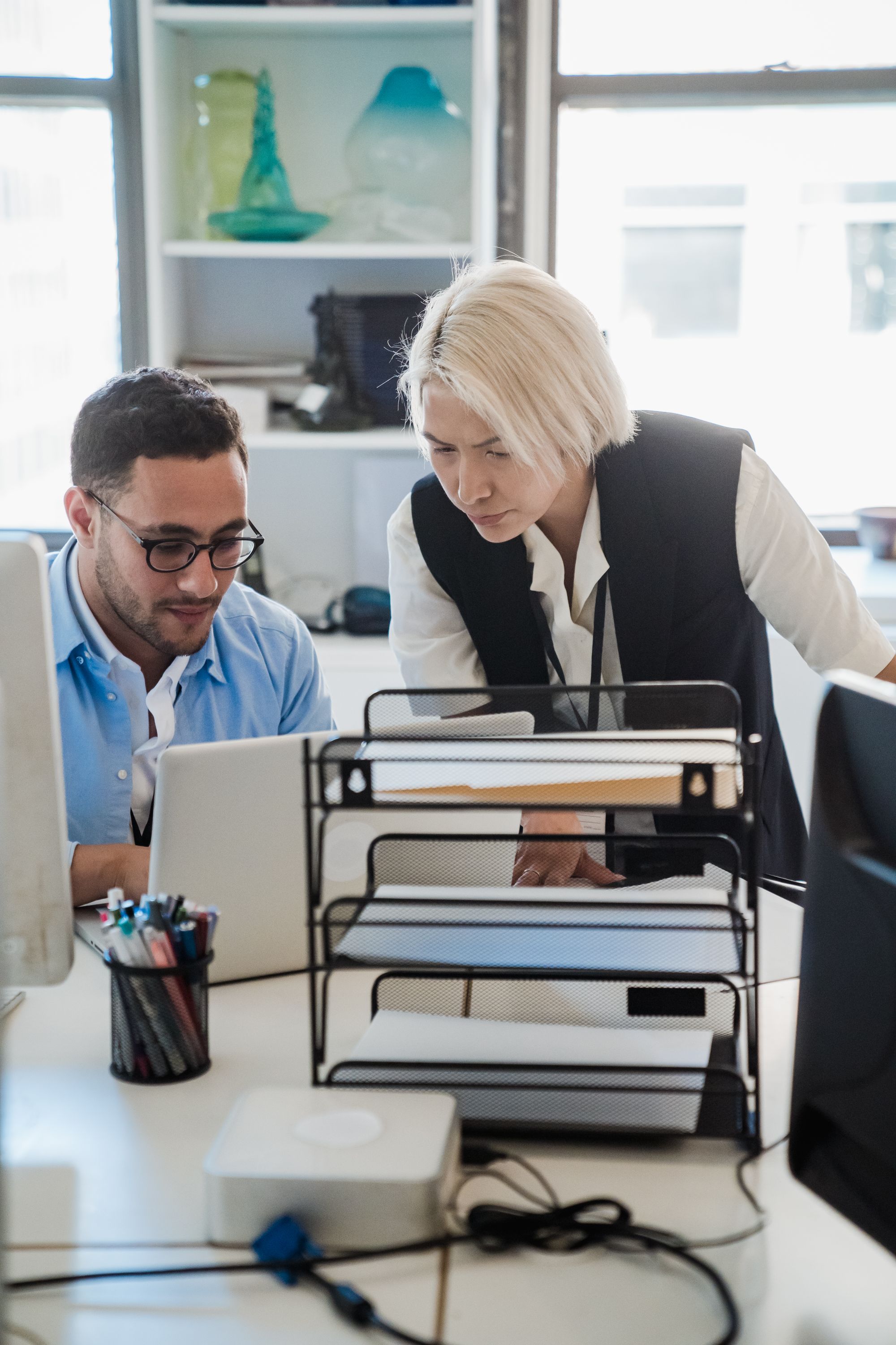Two colleagues working from the same screen